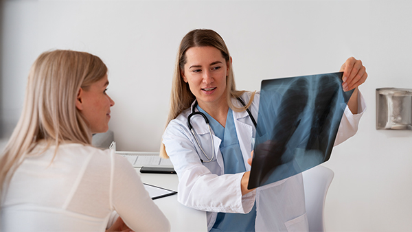 Doctor showing a chest X-ray to a patient in a medical consultation.